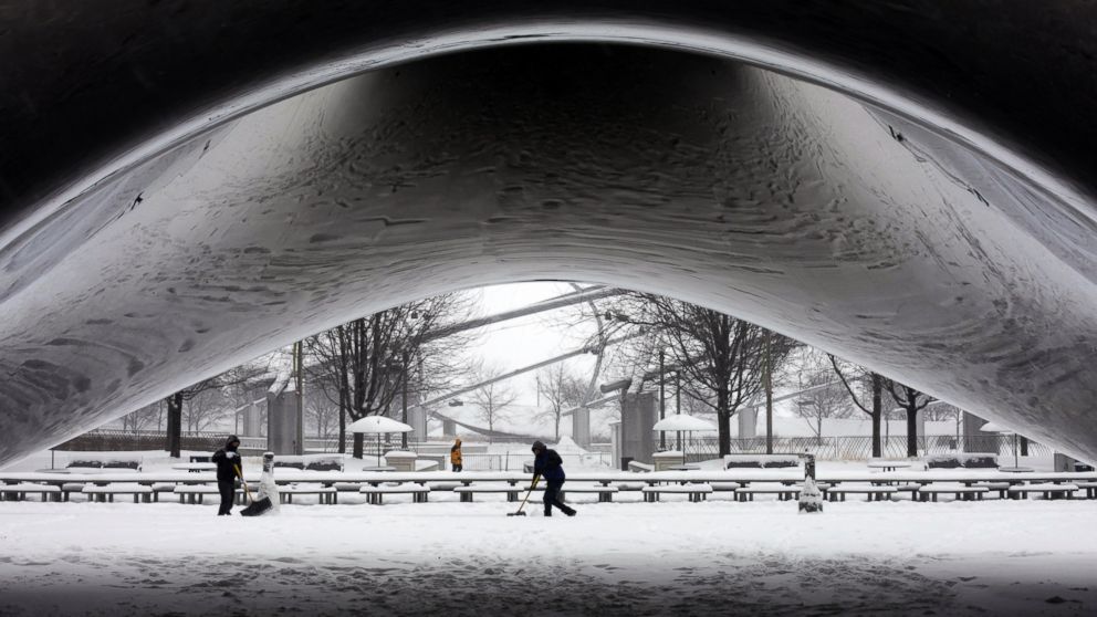 PHOTO: A park crew clears the snow around Annish Kapoors stainless steel Cloud Gate sculpture at Millennium Park, Jan. 2, 2014, as snow continues to accumulate in downtown Chicago.
