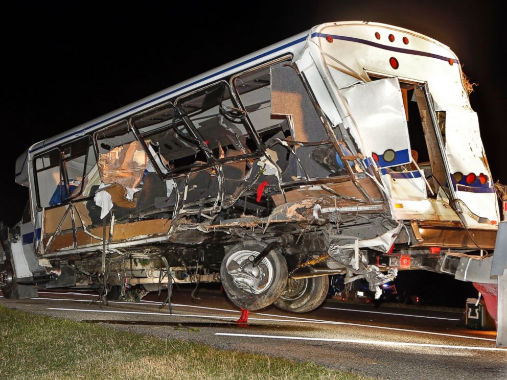 A wrecker removes the team bus as Highway Patrol and emergency personnel work the scene of a crash just south of the Turner Falls area on Saturday, Sept. 27, 2014 in Davis, Okla. Four members of a Texas college softball team died in the crash.