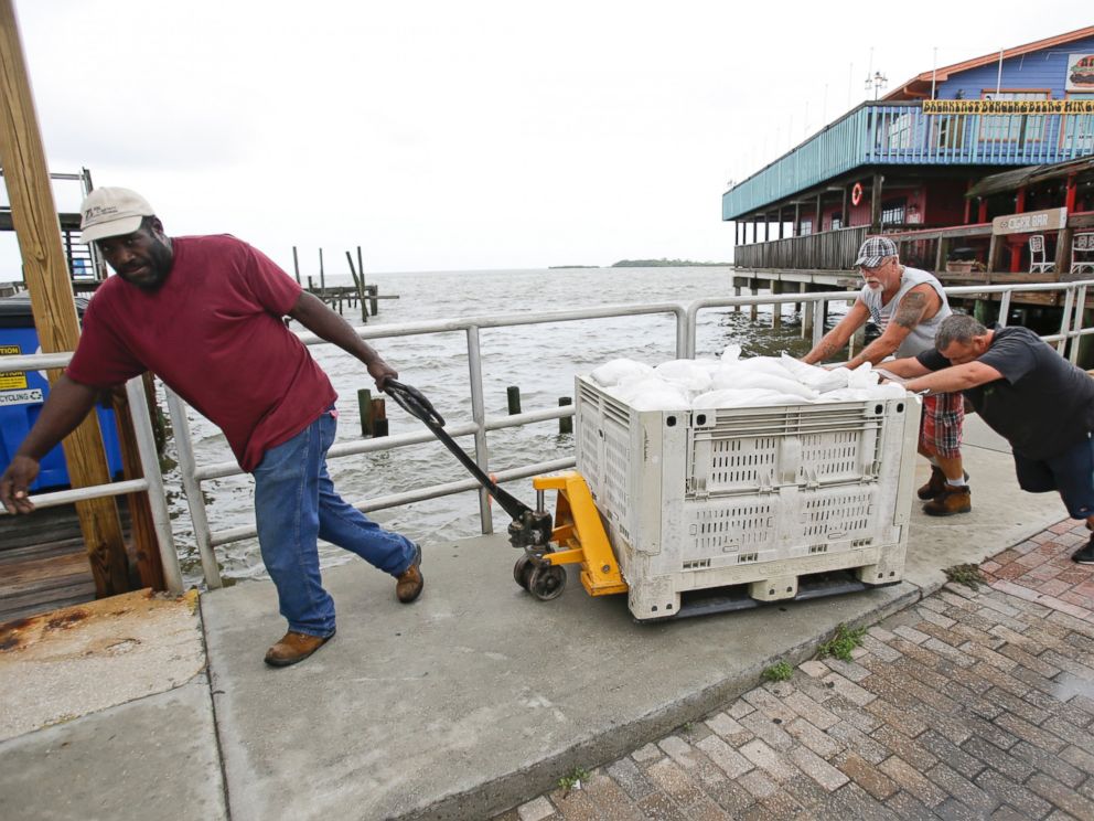 PHOTO: Les travailleurs se déplacent des sacs de sable pour protéger un restaurant à preperation pour la tempête tropicale Hermine, le 31 août, 2016, à Cedar Key, en Floride.