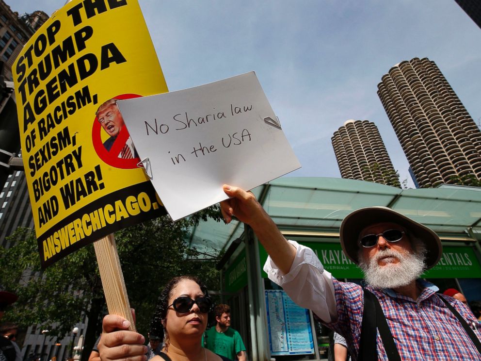 PHOTO: A pro-Muslim supporter (L) and a demonstrator with the March Against Sharia protest try to block out each others signs during a protest in Chicago, June 10, 2017.