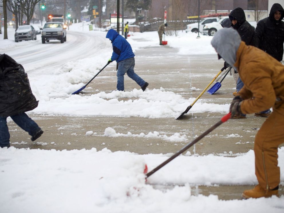 PHOTO: Men shovel a sidewalk March 14, 2017 in the Roxborough area of Philadelphia.