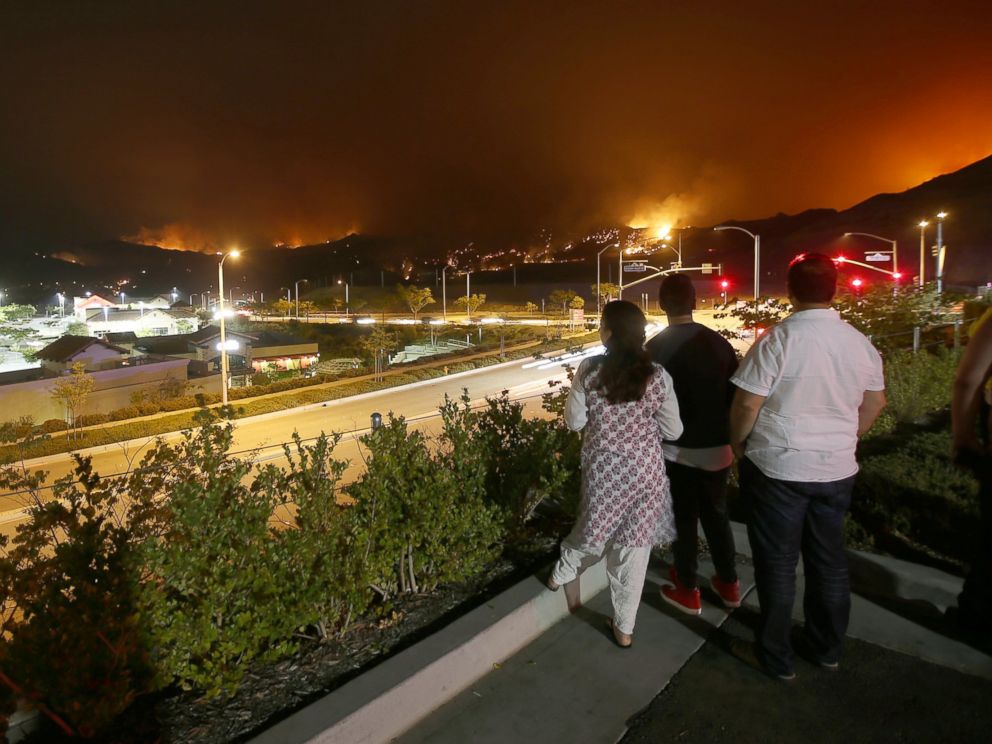 PHOTO: Onlookers gather at the parking lot of a shopping mall along Golden Valley Road in Santa Clarita to watch the Sand fire burn in the hills above the city on July 24, 2016.