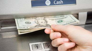 PHOTO: A person withdraws cash from ATM machine.