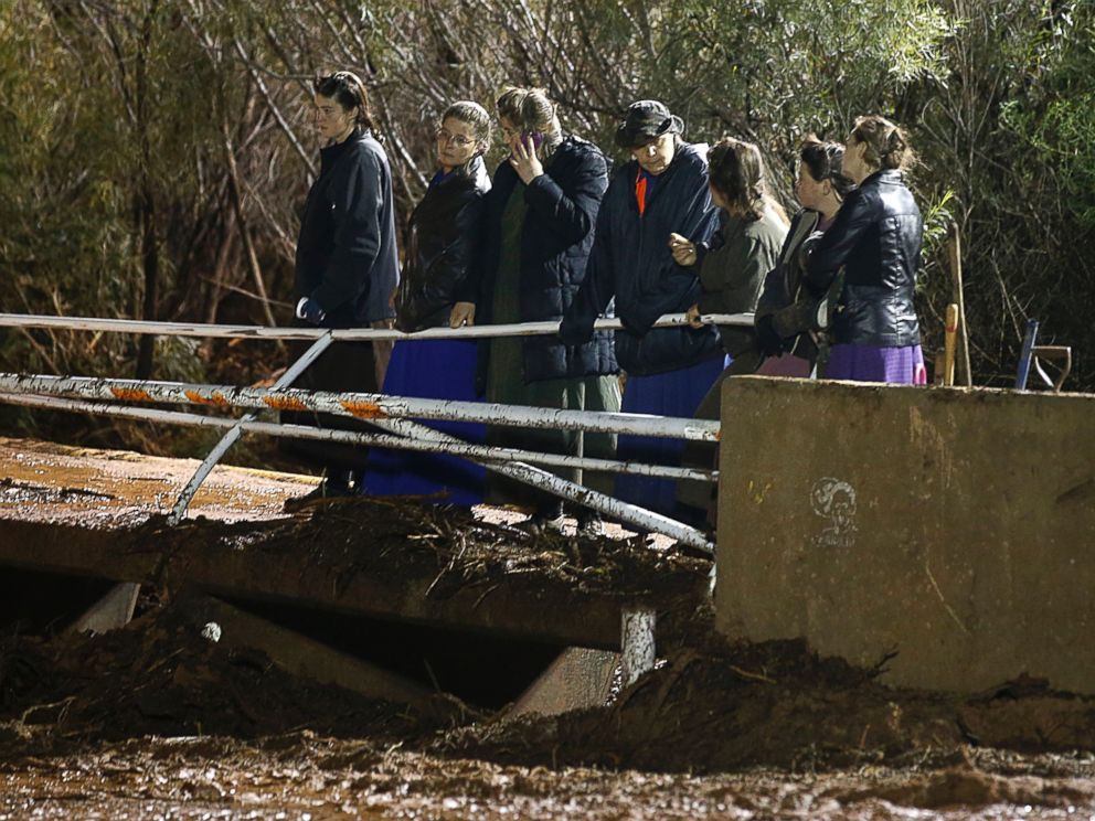 PHOTO:Several woman watch as large construction equipment is used to remove flood debris from Short Creek, Sept. 15, 2015 in Hildale, Utah.