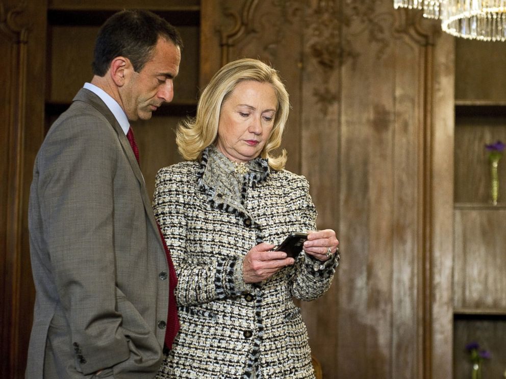 PHOTO: Hillary Clinton looks at a phone message with Assistant Secretary of State for European Affairs Philip Gordon as they wait in a conference room, Feb. 4, 2012.