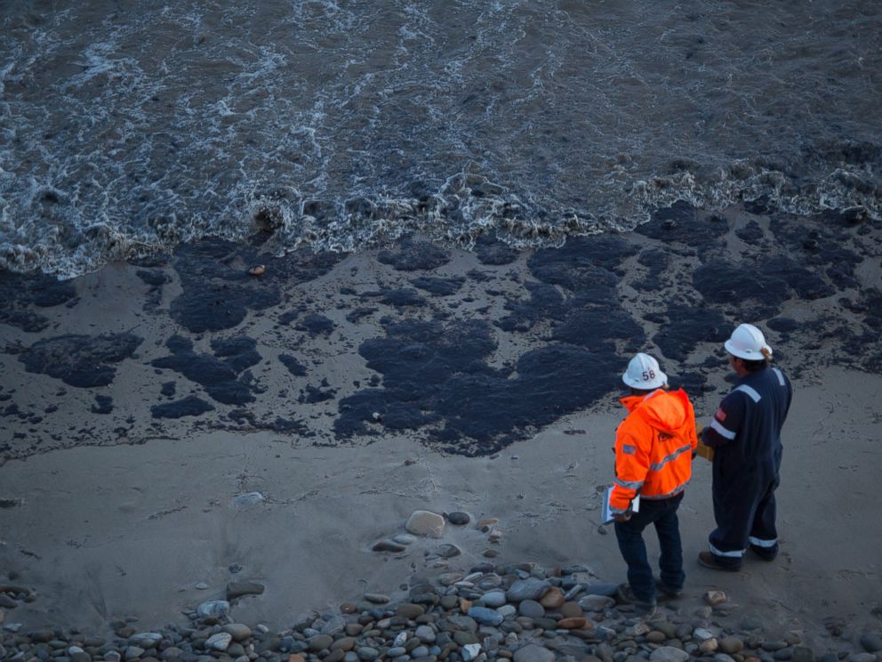 PHOTO: Officials walk along an the oil-covered beach on May 19, 2015 north of Goleta, Calif.