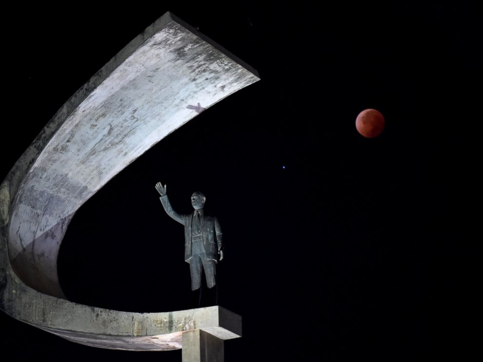 PHOTO: The moon during a total lunar eclipse over the Juscelino Kubitschek Memorial in Brasilia, Brazil.
