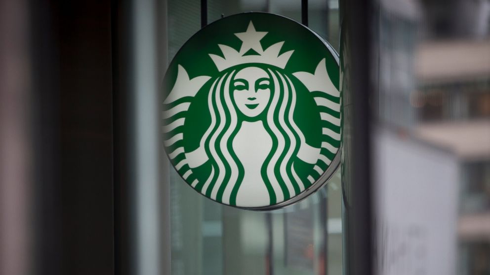 PHOTO: Pedestrians pass in front of a Starbucks Corp. location in New York, U.S., on Tuesday, April 23, 2013.