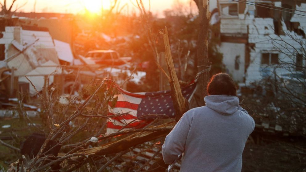 PHOTO: A person stands amongst damaged buildings along Washington Road in the aftermath of a tornado, Nov. 18, 2013 in Washington, Ill.