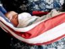 PHOTO: A picture of a baby being held by his father in an American flag sparked controversy online. 