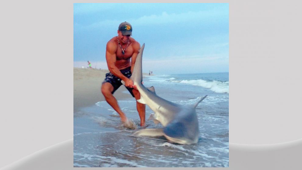 PHOTO:  Elliot Sudal is seen in this image wrestling a 7-foot-long shark to shore.