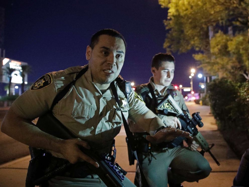 PHOTO: Police officers advise people to take cover near the scene of a shooting near the Mandalay Bay resort and casino on the Las Vegas Strip, Sunday, Oct. 1, 2017, in Las Vegas. 