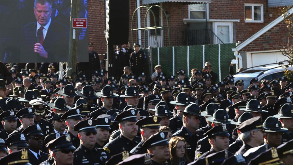 PHOTO: Law enforcement officers turn their backs on a video monitor as New York City Mayor Bill de Blasio speaks during the funeral of slain New York Police Department officer Rafael Ramos in the Queens borough of New York on Dec. 27, 2014.