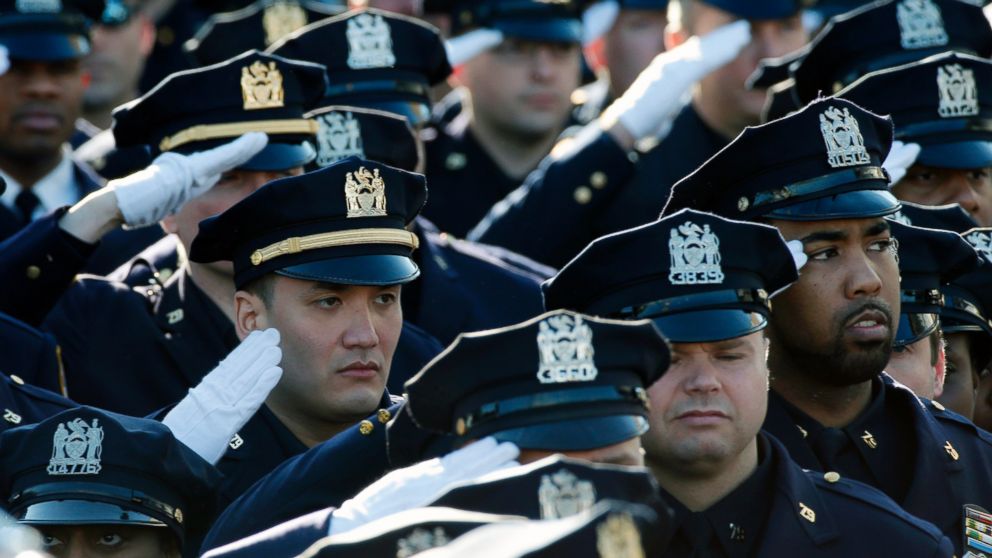 PHOTO: Police salute during the playing of the U.S. National Anthem outside the Christ Tabernacle Church at the start of the funeral service for slain New York Police Department officer Rafael Ramos in the Queens borough of New York, Dec. 27, 2014. 