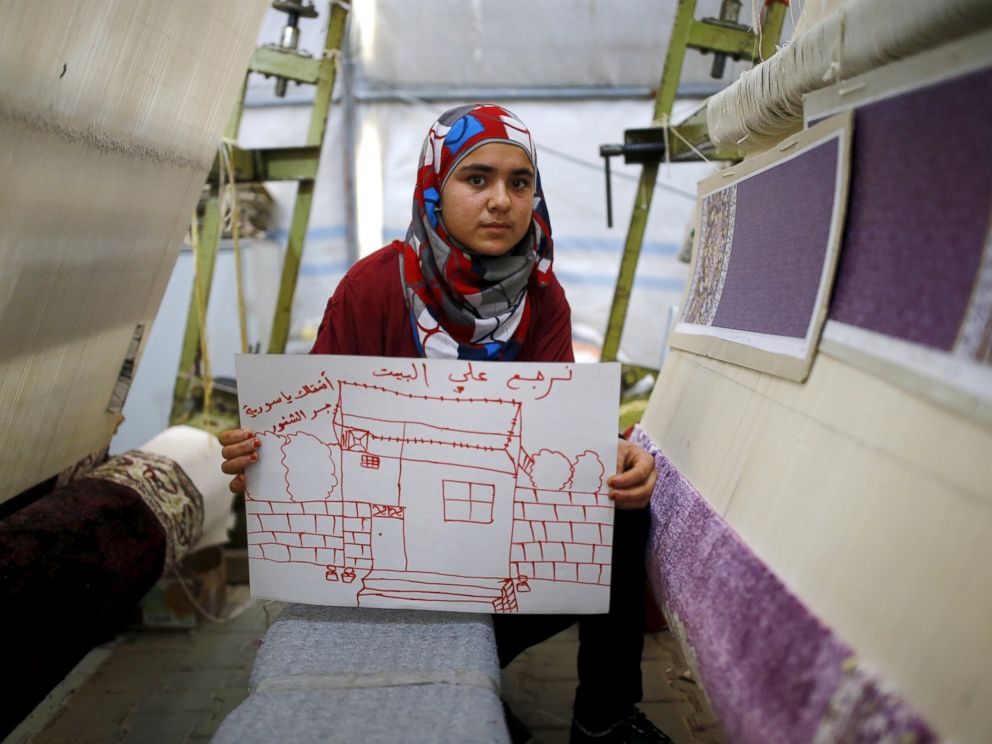 PHOTO: Syrian refugee Meryem Mahmo, 14, shows a drawing of her home during a carpet weaving workshop in Midyat refugee camp in Mardin province, Turkey, Dec. 14, 2015. The Arabic writing on the picture reads: I want my home. I miss you Syria.