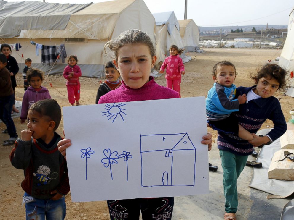 PHOTO: Syrian refugee Rahaf Hasan, 10, poses as she holds a drawing of her home in Syria in Midyat refugee camp in Mardin province, Turkey, Dec. 14, 2015.