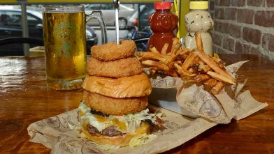 PHOTO: The Supreme Beef burgerseen here on a brioche bun with a side of Onion Rings and French fries, and a lionshead lager beer, is served at Bare Burger, Astoria Queens, July 25, 2012.