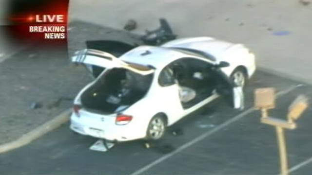 PHOTO: Police search the car of suspect, James Holmes, 24, of Aurora, who was caught by police in the parking lot of the Century 16 Movie Theaters, where at least 12 people were shot dead.