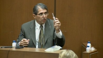 PHOTO: Witness for the Conrad Murray trial, Dr. Paul White, does a demonstration in court right with IV bags and syringes.