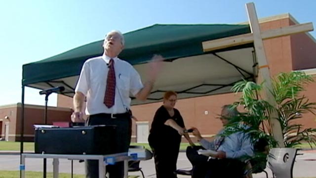 PHOTO: Rev. David Ray, pastor of Presbyterian Church of the Master, stands in the parking lot conducting the service as churchgoers watch through their dashboard windows.