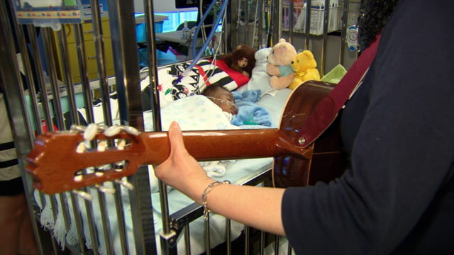 PHOTO: Music therapist Rebecca Loveszy serenades little Jadion, who was born with a heart defect.