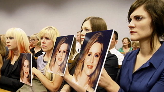 PHOTO: The daughters of Martin MacNeill hold up pictures of their dead mother during his first court appearance, Aug. 27, 2012.