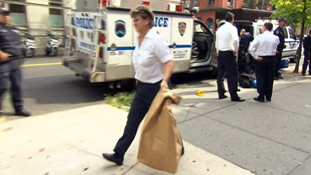PHOTO: A policewoman emerges carrying a large bag from the basement in SoHo where Etan Patz was allegedly killed, August 8, 2012, in New York City, N.Y.