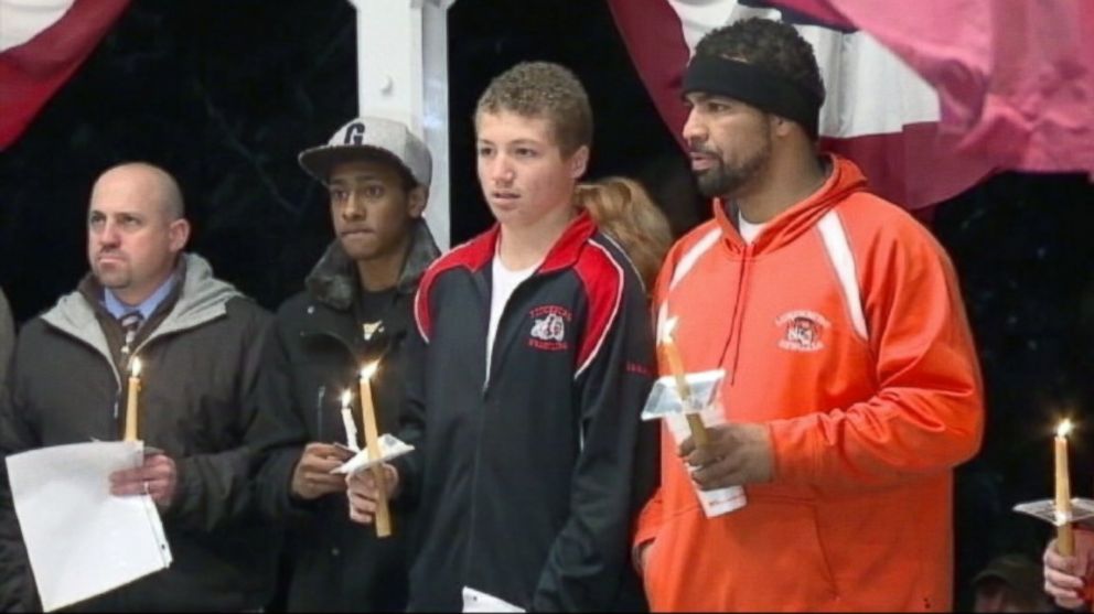 PHOTO: Lunenburg High School football player Isaac Phillips, second from right, is shown during a candlelight vigil in his honor.