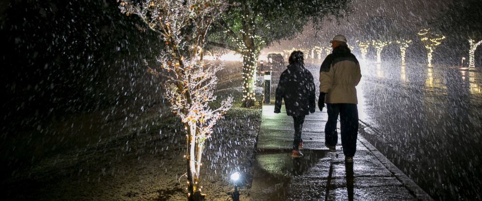 Larry and Licette Wagner walk in the snow on Escarpment Boulevard in Austin, Texas, on Thursday Dec. 7, 2017.