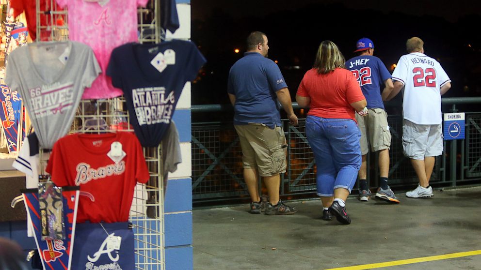 PHOTO: Baseball fans look over a railing at Turner Field near the scene where a man fell 60 feet from the upper deck Monday Aug. 12, 2013. Atlanta police spokesman John Chafee confirmed the death of the man, whose name has not been released.