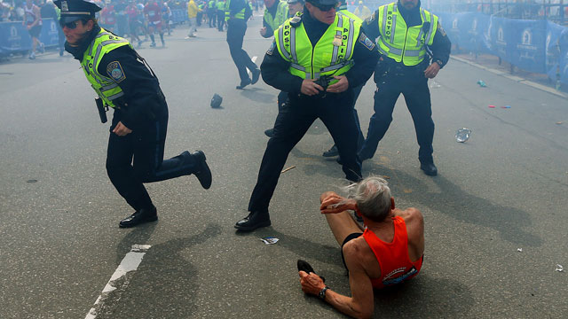 PHOTO: Bill Iffrig, 78, lies on the ground as police officers react to a second explosion at the finish line of the Boston Marathon in Boston, Monday, April 15, 2013.