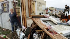 PHOTO: Marlena Hodson walks out of her home as her grandsons, Campbell Miller, 10, and Dillon Miller, 13, at right, help her sort through belongings after a tornado damaged her home Carney Okla., on Sunday, May 19, 2013.