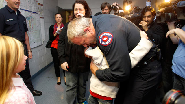 PHOTO: Rebecca Quintanilla, center left, wipes tears from her face as her adopted son Koregan, 10, hugs Arlington Fire Fighter Wesley Keck, center right, as the two meet Nov. 15, 2012, in Arlington, Texas.