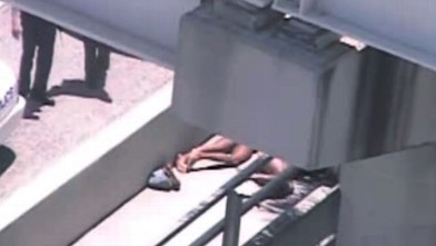 PHOTO: In this image taken from video, Miami police officers stand watch near Rudy Eugene, second from right, who was shot dead by a police officer when he refused to stop chewing on the face of Ronald Poppo, partially obscured by a railing, in Miami, May