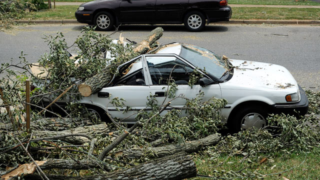 PHOTO: A car sits crushed by a fallen tree on Carrington Road in Lynchburg, Va. on July 1, 2012.