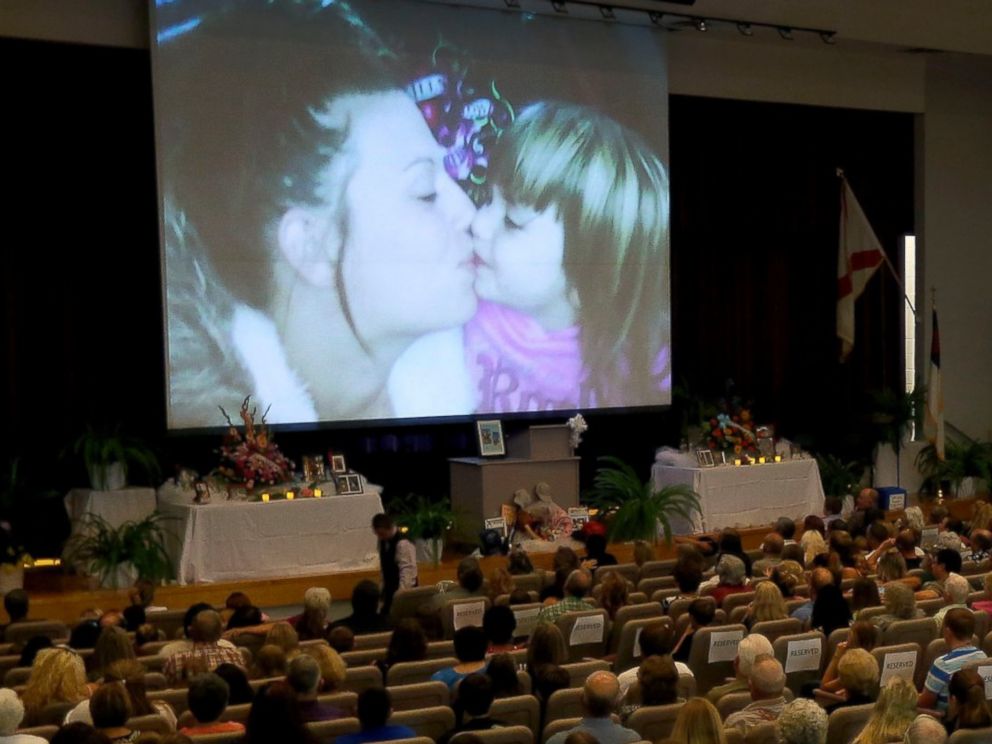 PHOTO: Photos of Sarah Spirit and her children are displayed on the screen during a memorial service at Bell High School Don Spirits family on Sept. 21, 2014, in Bell, Fla.