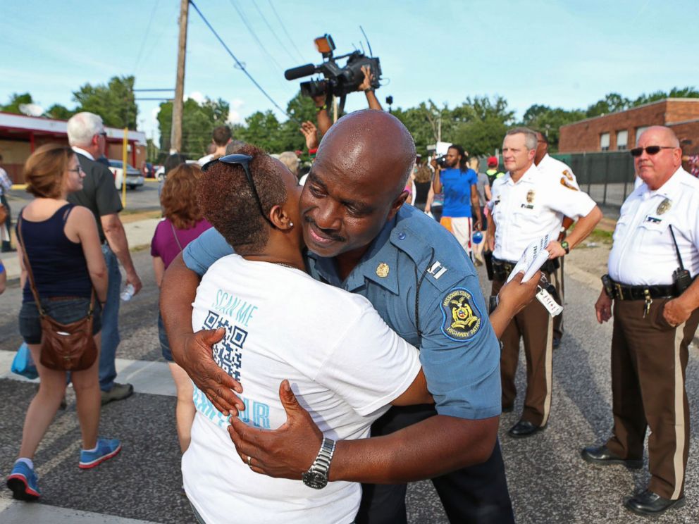 PHOTO: Capt. Ronald Johnson of the Missouri Highway Patrol hugs Angela Whitman, of Berkeley, Mo., on West Florissant Avenue in Ferguson, Mo., on Aug. 14, 2014.