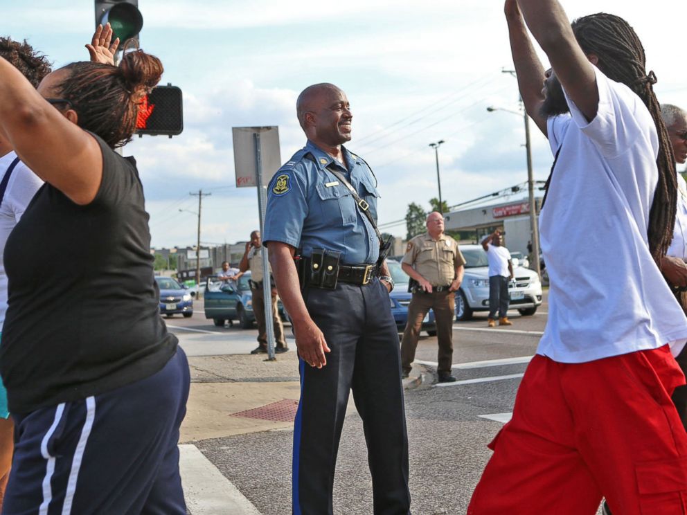 PHOTO: Capt. Ronald Johnson of the Missouri Highway Patrol smiles at demonstrators march along West Florissant Avenue in Ferguson, Mo., on Aug. 14, 2014.