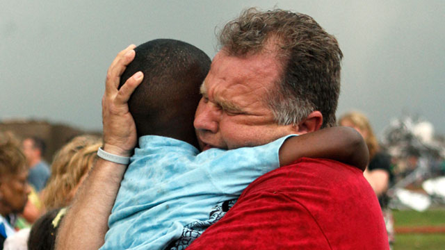 PHOTO: A teacher hugs a child at Briarwood Elementary school after a tornado destroyed the school in south Oklahoma City, May 20, 2013.