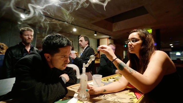PHOTO: A patron inhales marijuana vapor just after midnight March 2, 2013, with the help of a bar worker in the upstairs lounge area of Stonegate, a pizza-and-rum bar in Tacoma, Wash.