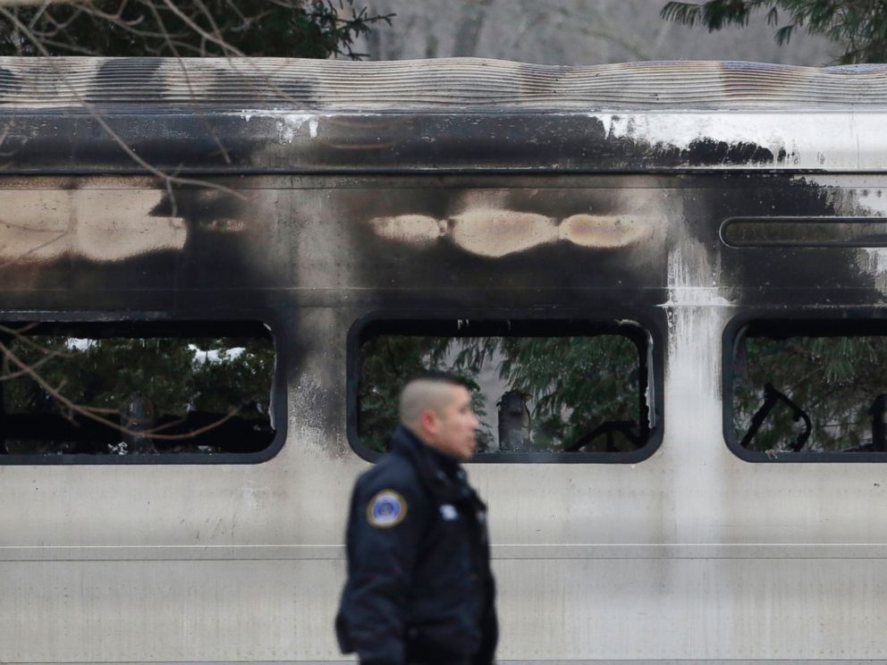 PHOTO: A police officer walks by burned and blackened windows of a Metro-North train stopped on the tracks, on Feb. 4, 2015, in Valhalla, N.Y.