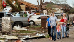 PHOTO: People walk through a neighborhood south of SW 149th between Western and Hudson after a tornado struck south Oklahoma City and Moore, Okla., May 20, 2013.