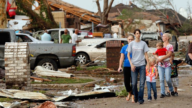 PHOTO: People walk through a neighborhood south of SW 149th between Western and Hudson after a tornado struck south Oklahoma City and Moore, Okla., May 20, 2013.