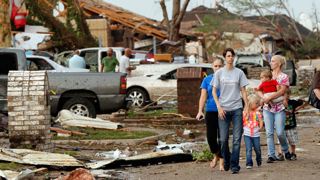 PHOTO: People walk through a neighborhood south of SW 149th between Western and Hudson after a tornado struck south Oklahoma City and Moore, Okla., May 20, 2013.