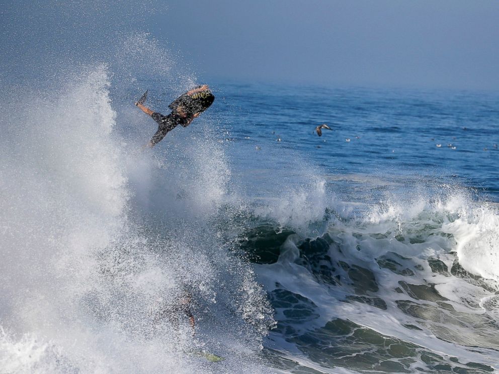 PHOTO: A bogie boarder flies over a wave a surfer rides underneatch a wave at the wedge in Newport Beach, Calif., Aug. 27, 2014.