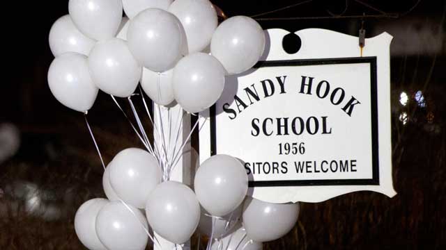 PHOTO: White balloons decorate the sign for the Sandy Hook Elementary School as a Connecticut State Trooper stands guard at the schools entrance, Dec. 15, 2012, in Newtown, Conn.