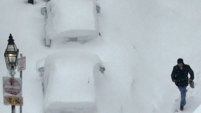 PHOTO:&nbsp;A man walks past snow covered cars in the South End neighborhood of Boston, Saturday, Feb. 9, 2013. The Boston area received about two feet of snow from a winter storm.