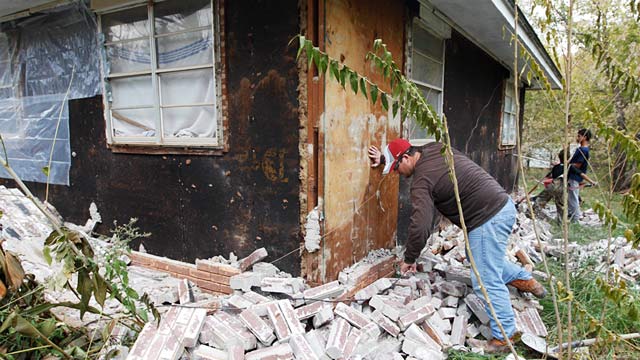 PHOTO: Man clears bricks from house after earthquake