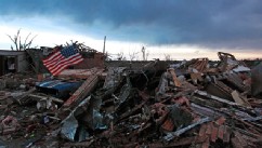 PHOTO: An American flag blows in the wind at sunrise atop the rubble of a destroyed home in Moore, Okla., on May 21, 2013, a day after a tornado roared through the Oklahoma City suburb, flattening entire neighborhoods and destroying an elementary school w
