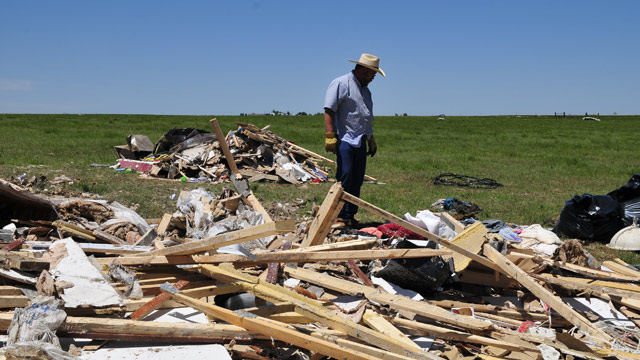 PHOTO: John Chapman looks over what little is left of his daughter Lauren Porters double wide that was picked up and strewn over a cattle pasture by a tornado, Saturday June 1, 2013 in El Reno Okla.